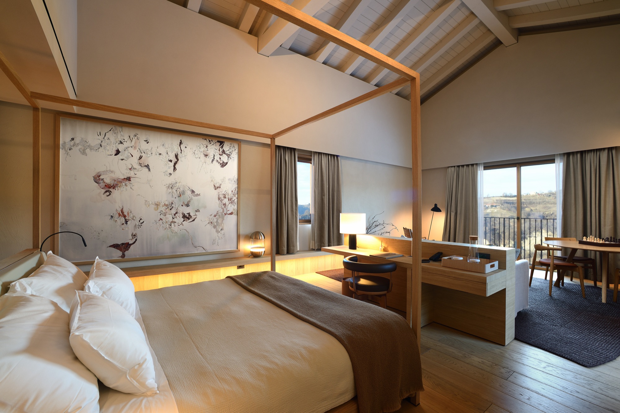 Alta Langa Suite with a canopy bed and a large painting