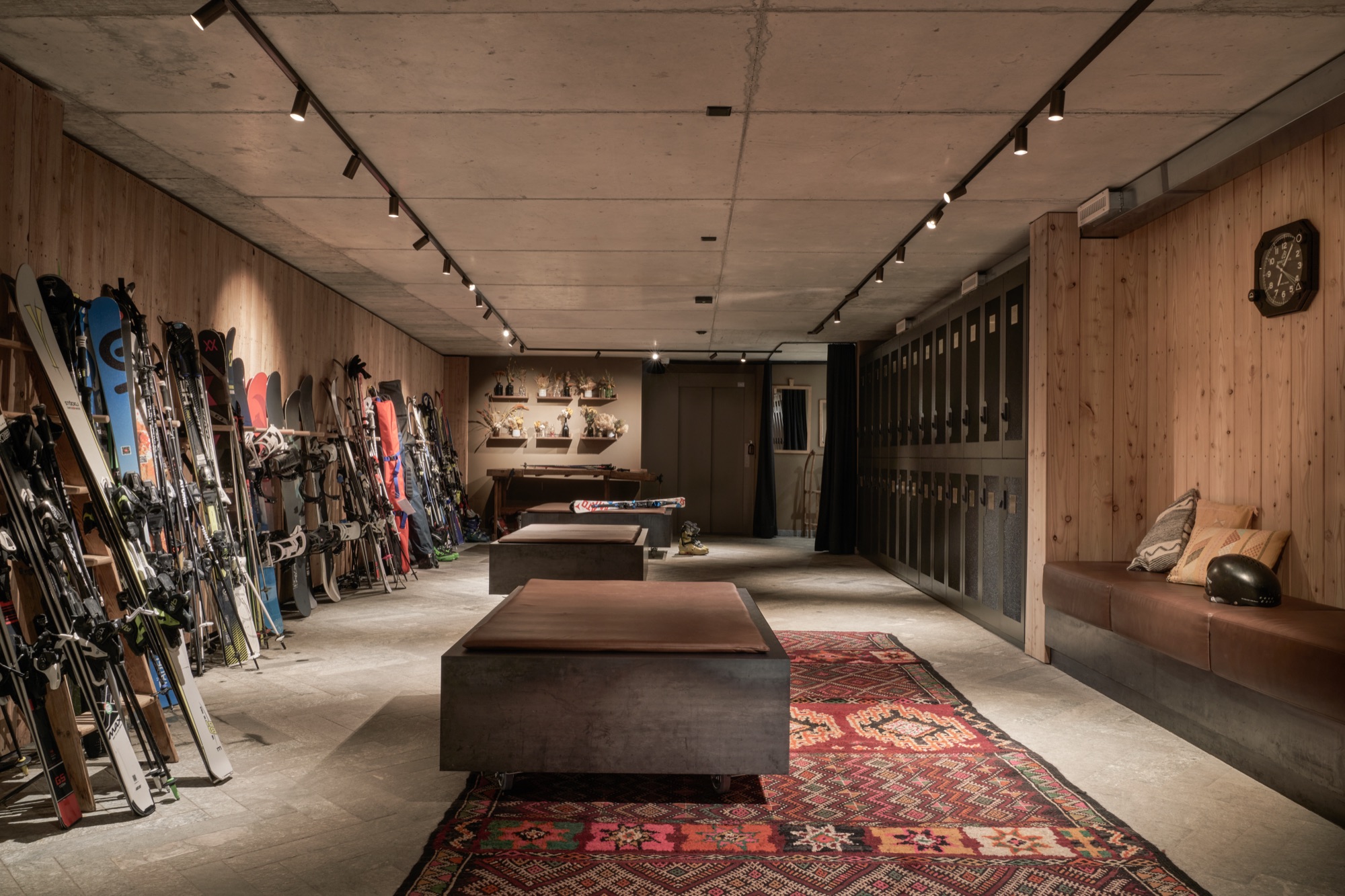 Ski room with skis lined along a timber wall