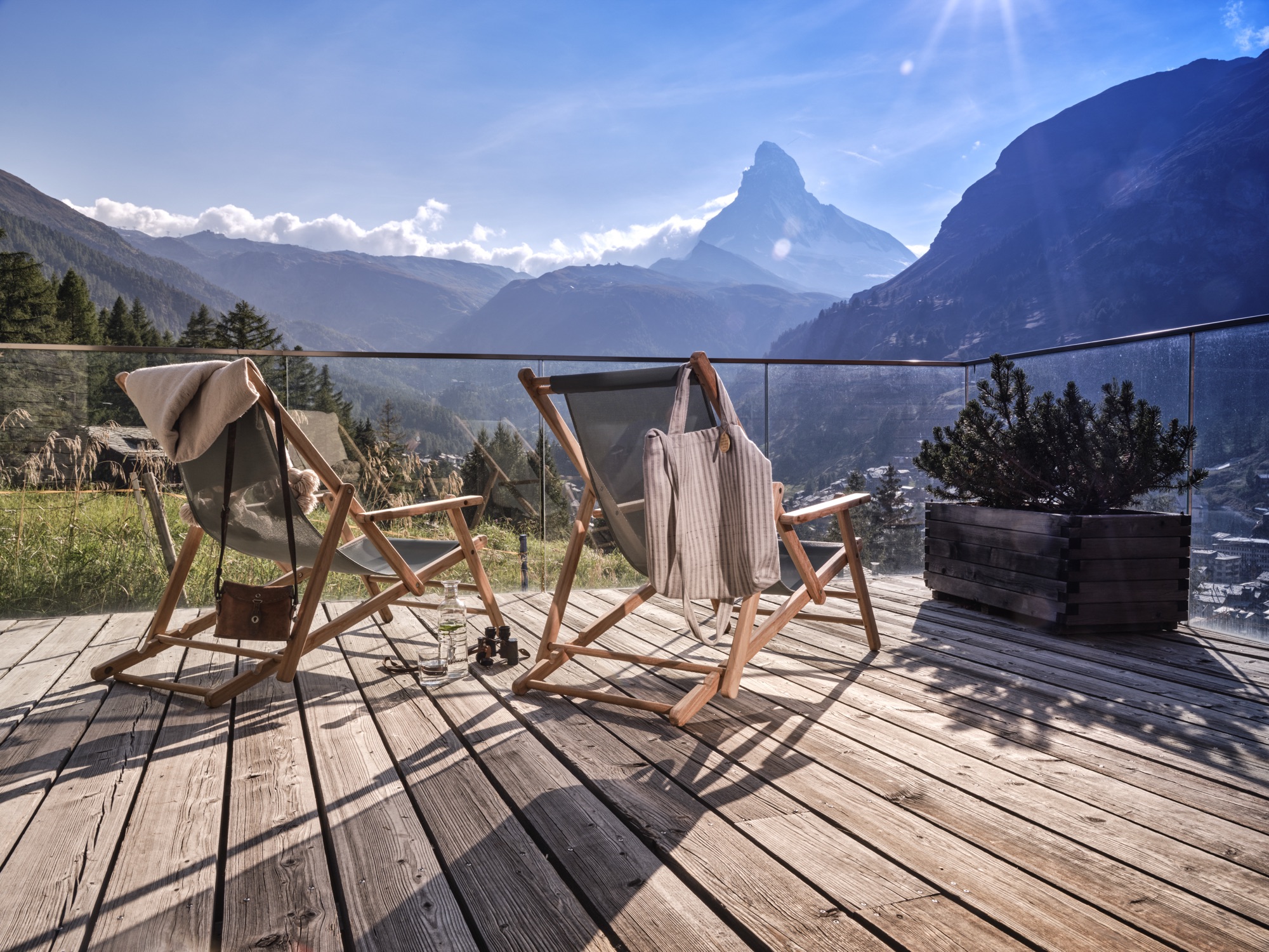 Two deckchairs on a wooden terrace facing the Matterhorn