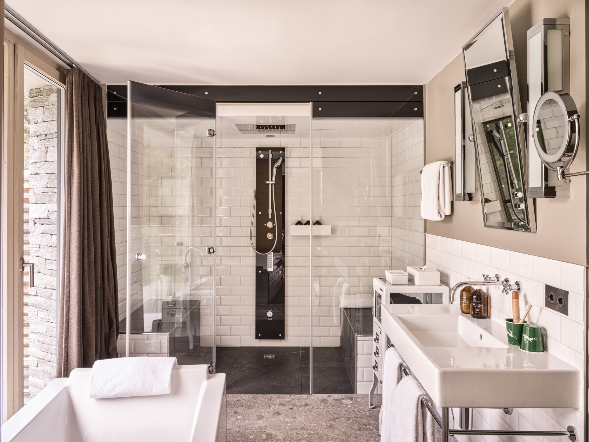 White tiled bathroom with a glass shower and a bathtub