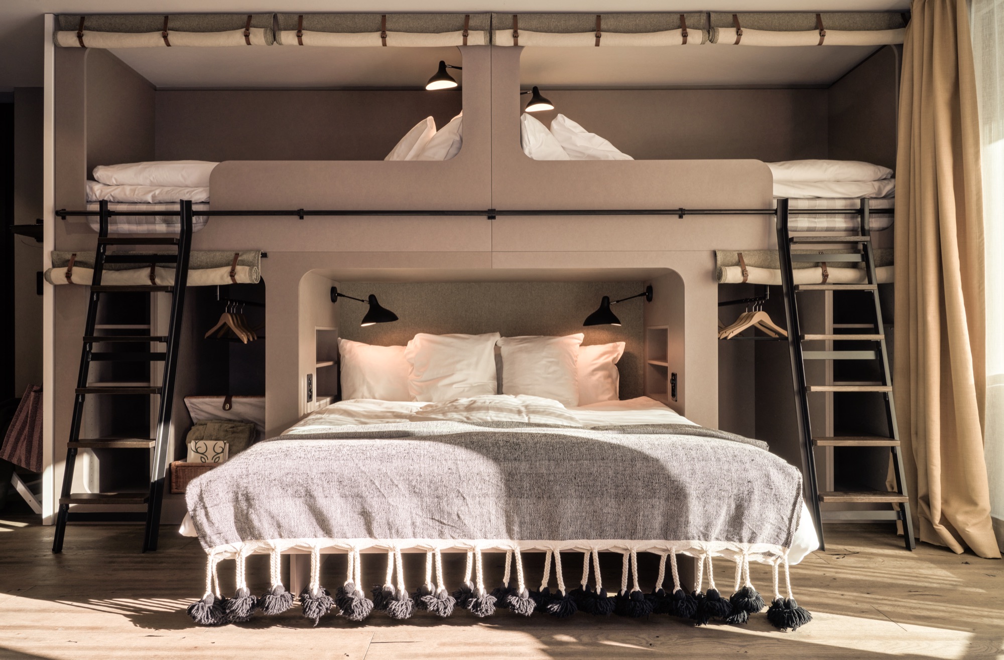 Room with a double bed set between two bunk beds
