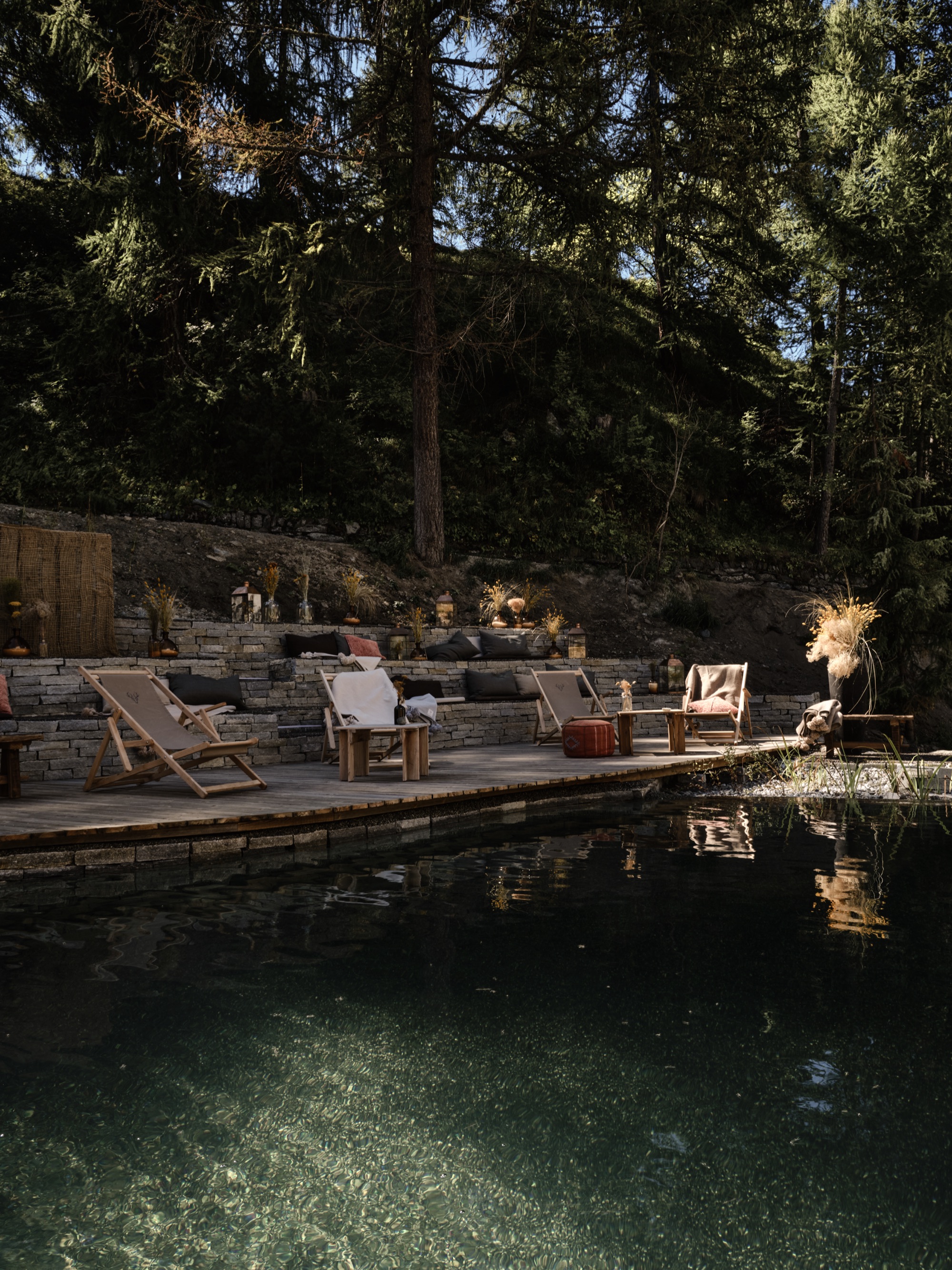 The spa's natural pool at dusk, with loungers on the terrace above