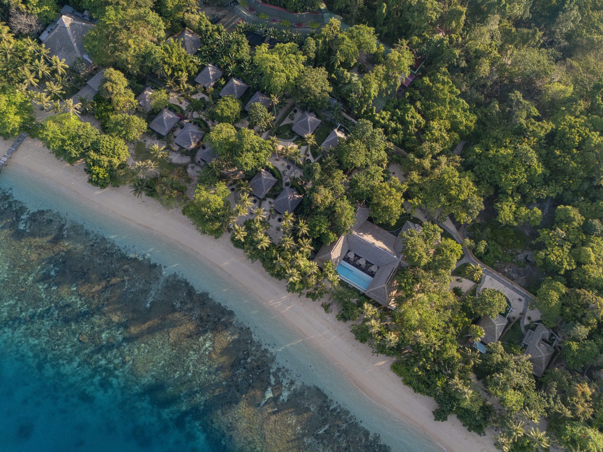 Aerial view of Coral Eye and its beach on Bangka Island at sunset