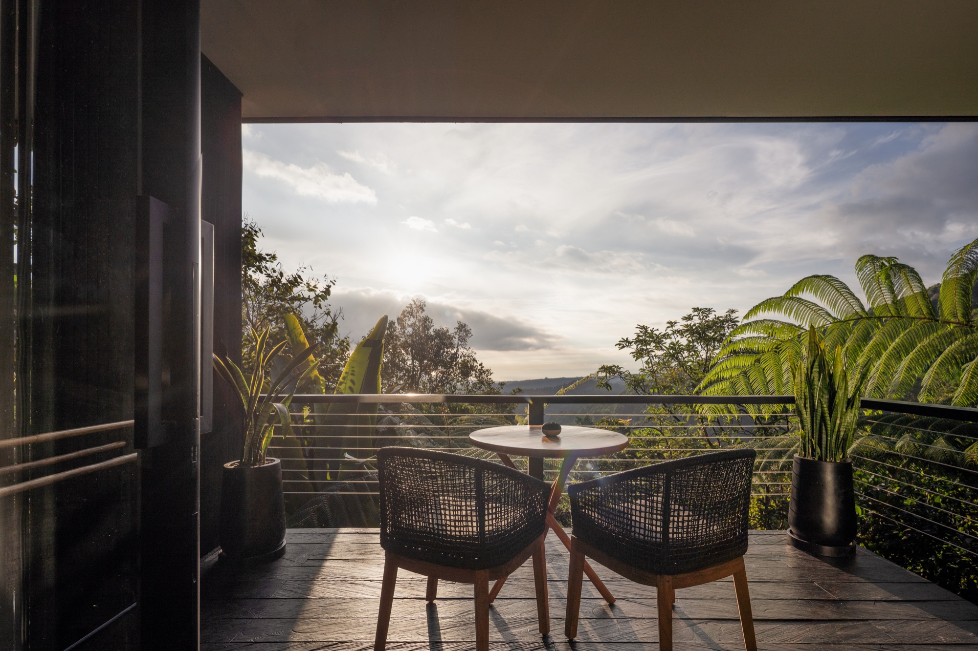Cabin balcony table for two looking out over the misty hills of North Bali at sunset