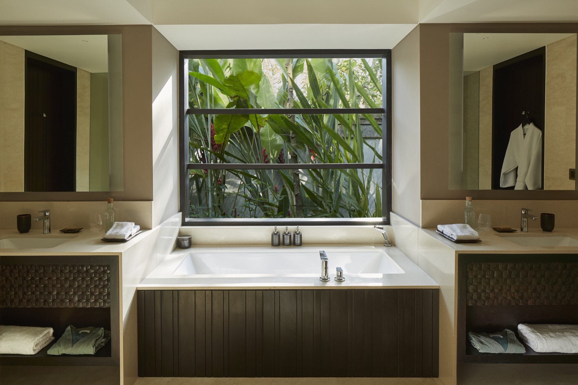 Bathroom with soaking tub and a window onto the jungle at a Jungle Pool Pavilion