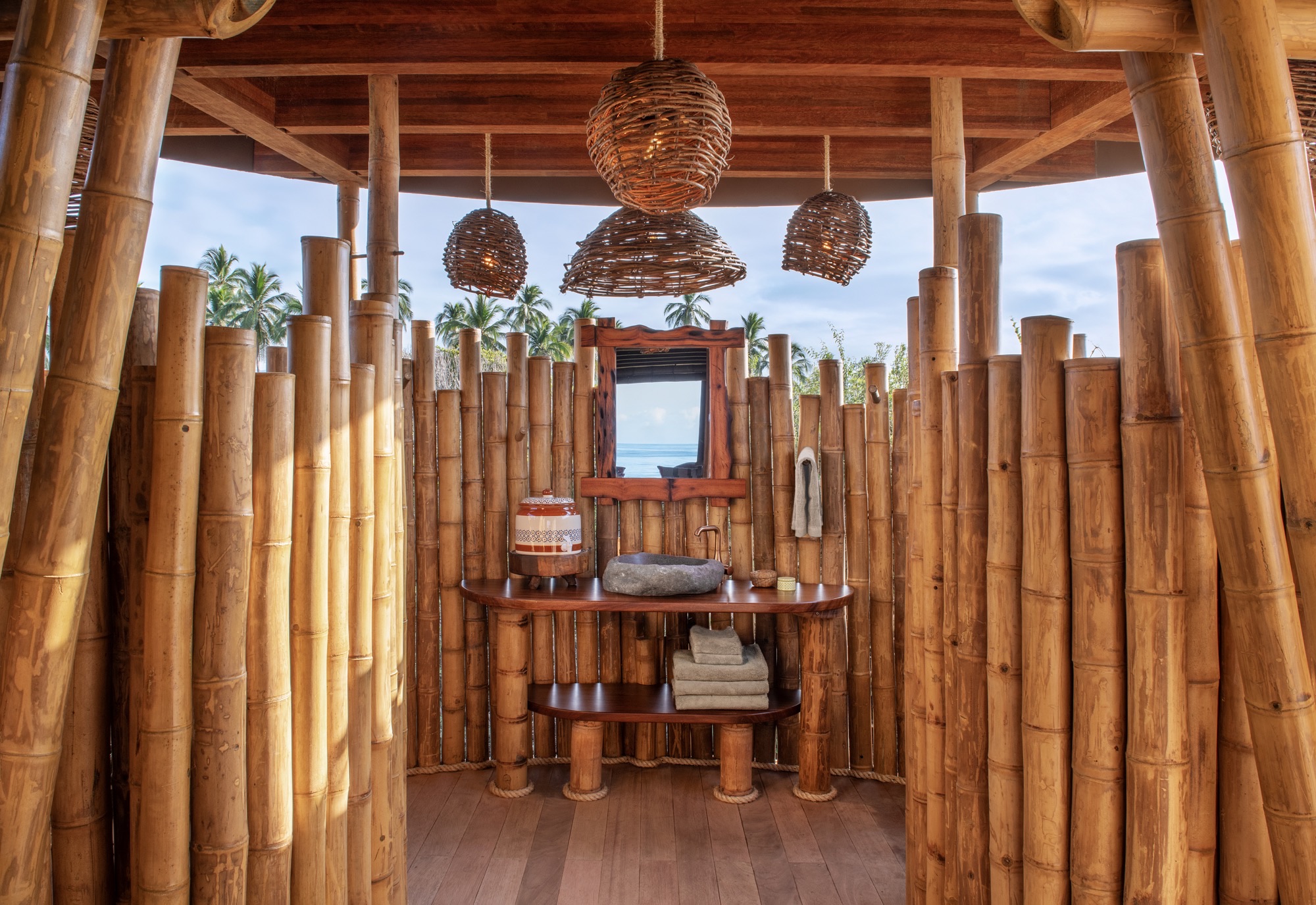 Open-air bathroom of the Infinity Casita, walled with bamboo poles