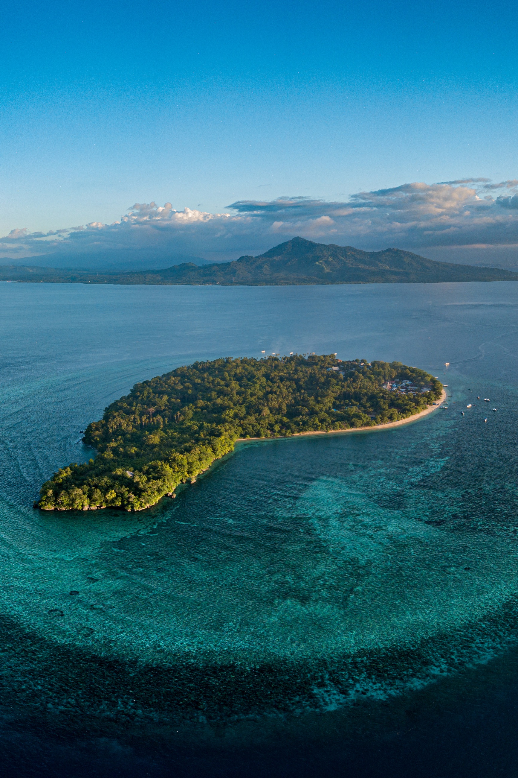 Aerial view of Siladen island and its reef, with Manado Tua beyond, Bunaken Marine Park