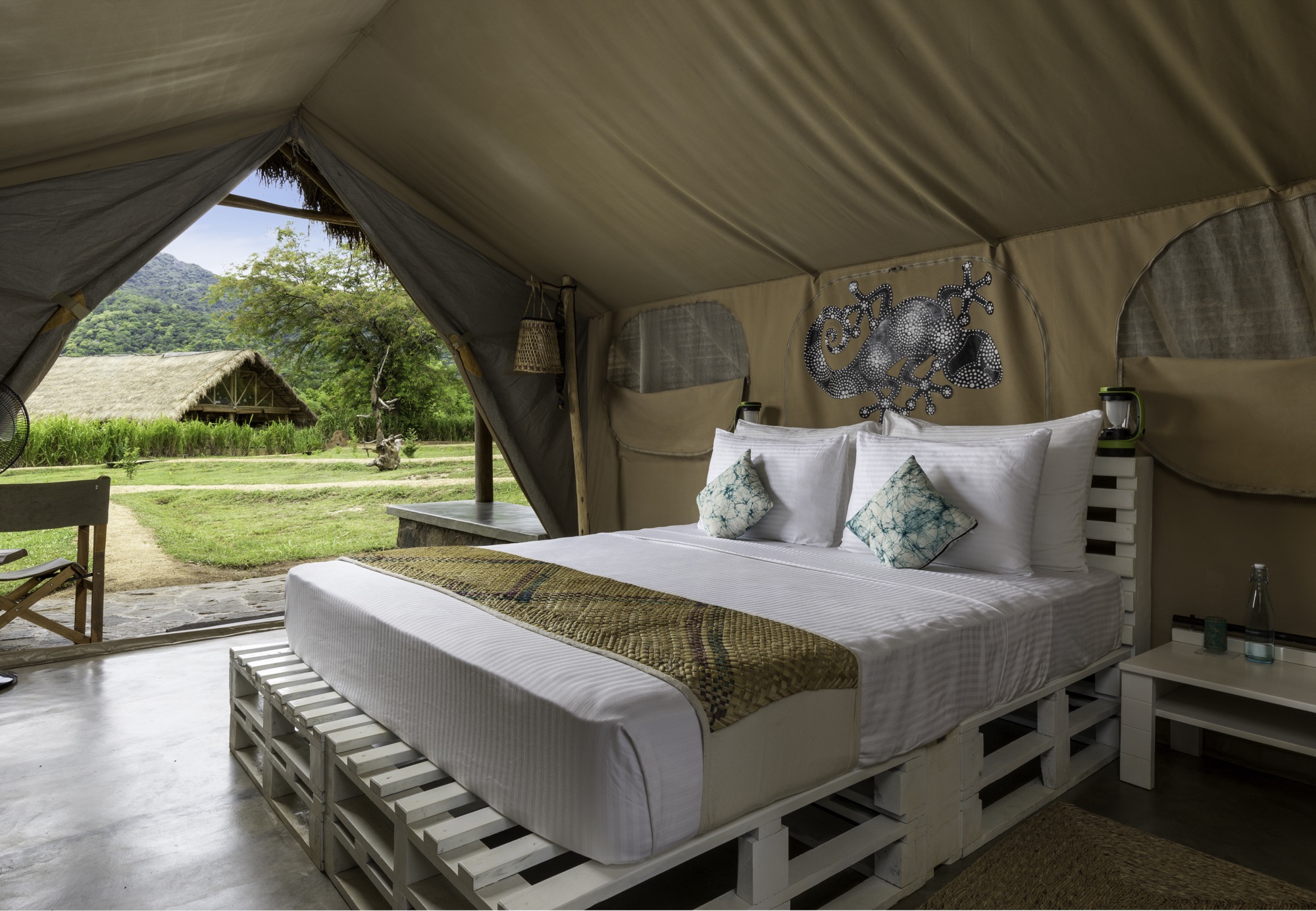 Deluxe Tent bedroom with king bed, opening onto the savannah and mountains