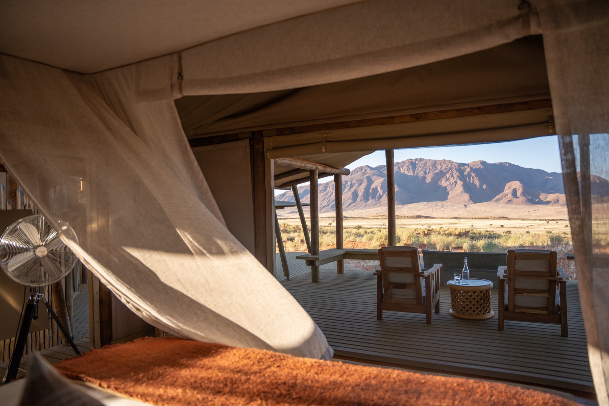 View from the bed onto the deck armchairs and the mountains