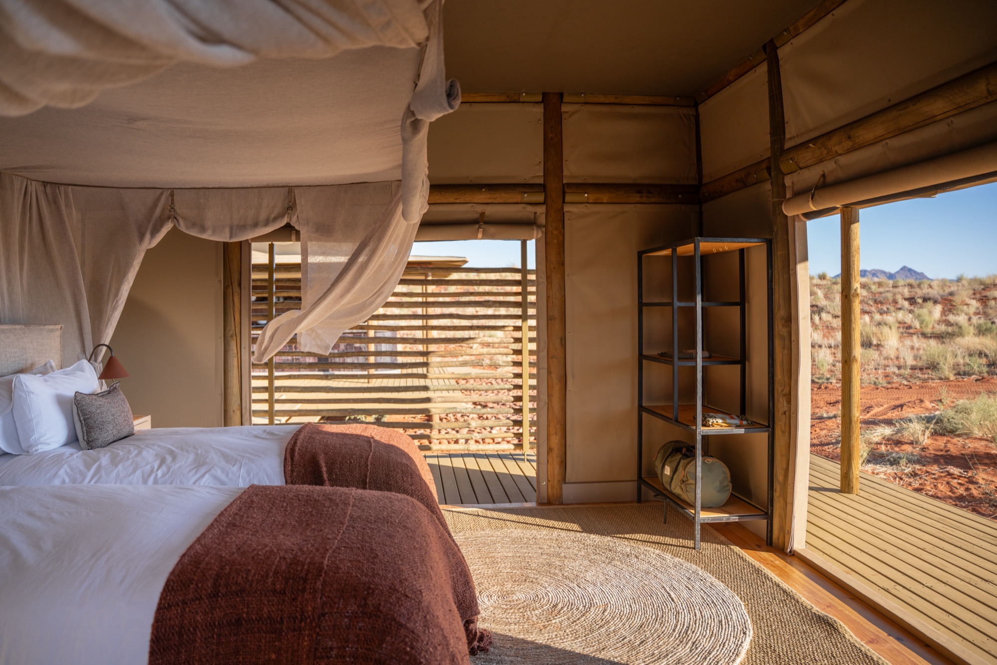 Family Suite bedroom with a mosquito net and doors open onto the desert