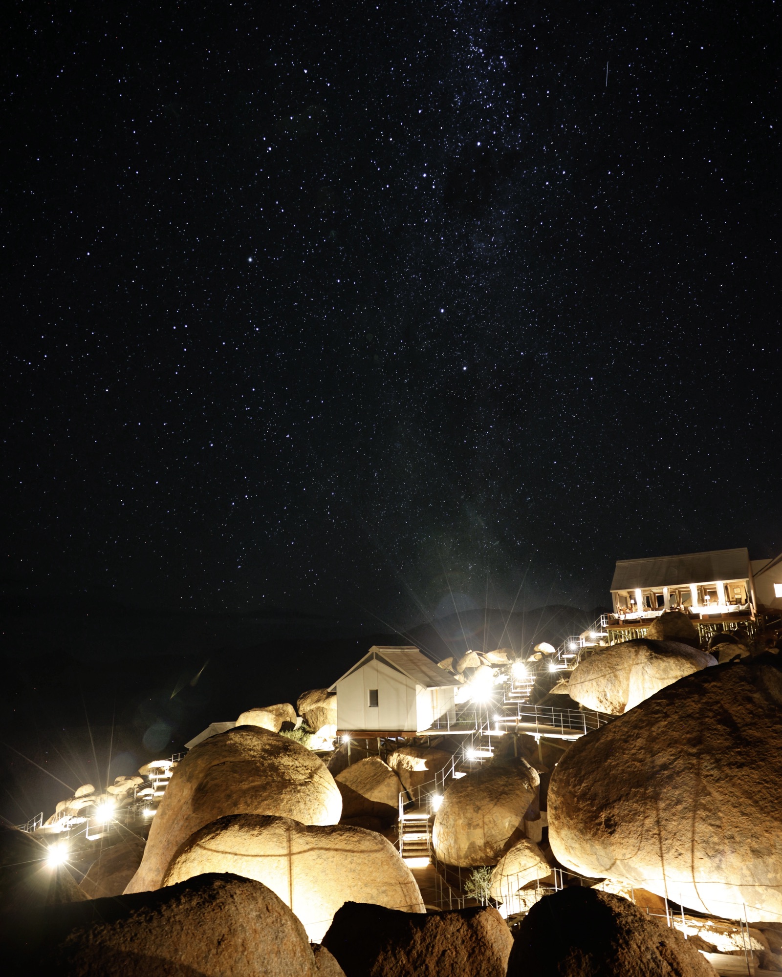 The lodge lit up among the boulders under a starry sky