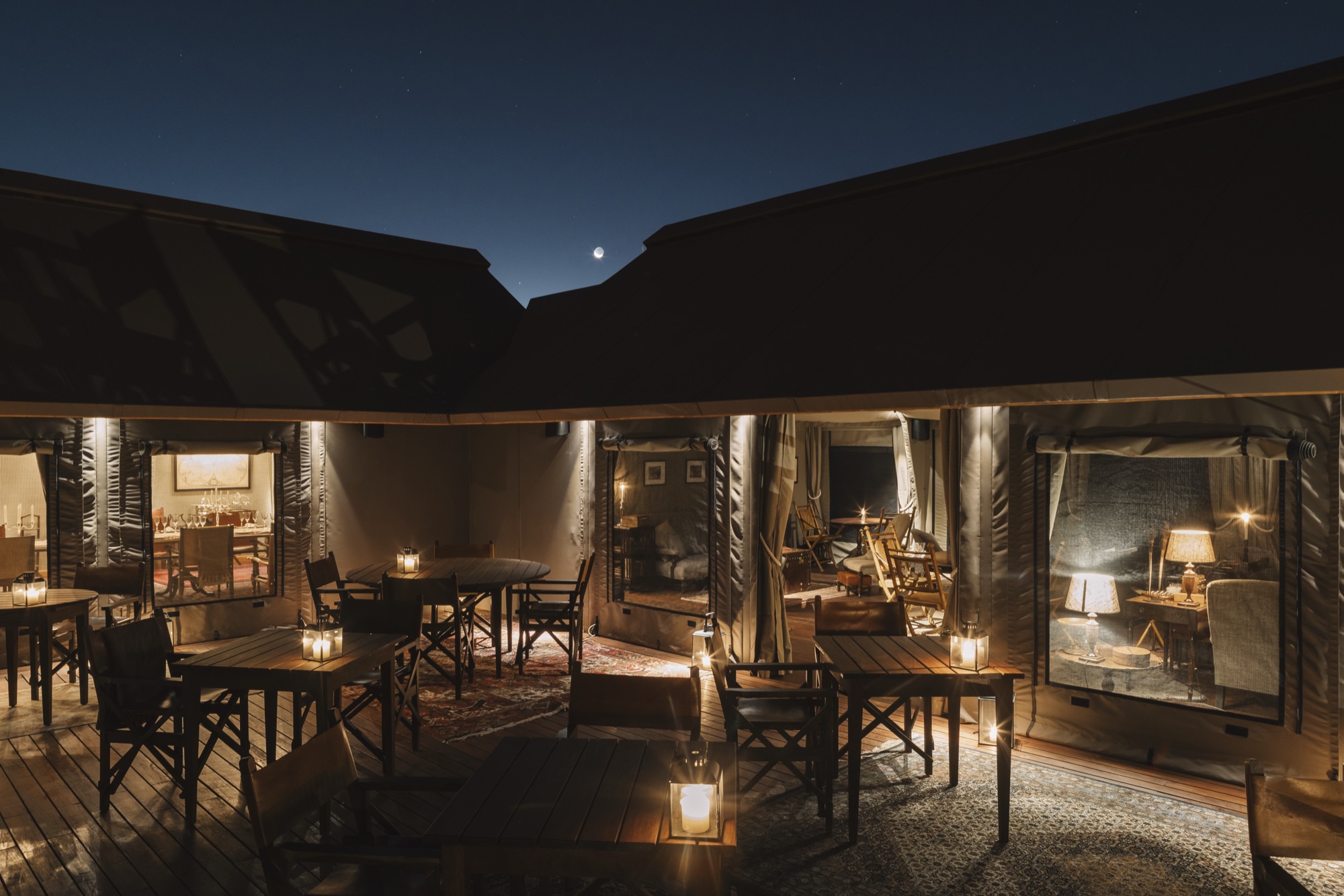 The main tent's terrace lit by lanterns at night