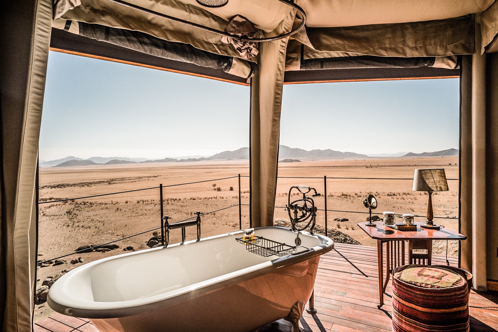 Clawfoot bathtub facing the desert through the open canvas